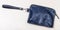 Closed small wristlet purse bag on pale table