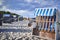 Closed traditional beach chairs on a sandy beach under dramatic looking storm clouds