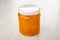 Closed transparent jar with orange jam on table