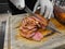 Closed up of chefâ€™s hand slicing grilled medium rare beef steak on wooden board Barbecue