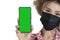 Closed-up female tourist face holding smartphone shown green sereen on white background