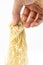 Closed up hand pulling uncooked egg noodle