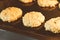 Closed up of hot baking oatmeal raisin cookies on black plate pan in the oven, using raisin and oat for main ingredient