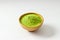 Closed up isolate heap of extract Green Tea powder in wooden bo