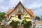 Closed up a pair of flower bouquets for offering Lord Buddha with blurred Wat Phumin temple in background, Nan province, Thailand