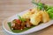 Closed Up Sauteed Beef and Deep Fried Sticky Rice Balls with Fresh lettuce in a White Plate on Wooden Table