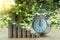 Closed up shot of alarm clock with Coin stacks on green background.