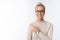 Closed-up shot of beautiful caucasian blond woman in glasses and sweater feeling creative and productive pointing at