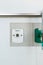 Closed up vacuum outlet on white wall by green oxygen outlet