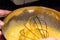 Closed view of a hand beating eggs with butter and lemon in a metal bowl. Preparing a homemade recipe for Christmas. Preparing the