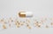 Closed white golden pill capsules on background of pile plastic cylinder, medical tablets. Pharmaceutical drug, omega 3