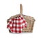 Closed wicker picnic basket with checkered blanket on white