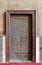 Closed wooden aged door with ornate bronzed geometric patterns