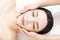 Closed young woman face and head massage in spa
