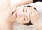 Closed young woman face and head massage in spa