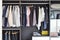 Closet with row of cloths hanging in black wardrobe