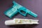 Closeup of 3D printed turquoise and white "Ghost Gun" on a dark background.