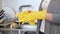 Closeup 4k footage of young housewife taking off yellow latex gloves after doing housework on kitchen
