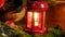 Closeup 4k video of candle burning inside red decorative lantern on wooden table decorated for celebrating Christmas or