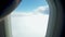 Closeup 4k video of hand opening blinds on the airplane porthole while flying above the clouds