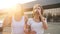 Closeup 4k video of two happy girls smiling, talking and drinking coffee while walking on parking lot at shopping mall