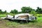 Closeup of abandoned damaged airplane wings at grassland field with trees background