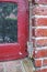 Closeup of abandoned red window covered in spiderwebs from neglect, poverty and economic crisis. Empty, old and dirty