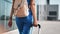 Closeup active female tourist carrying suitcase and backpack going to flight departure gate outdoor