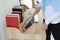 Closeup active young asian muslim housewife woman hands cleaning with vacuum cleaning wooden table with computer blurred