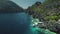 Closeup aerial view of boat at ocean cliff coast with green tropical forest. Exotic nature landscape