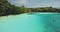 Closeup aerial view of limpid lake on green cliff ocean shore. Indonesia landscape of Weekuri lagoon