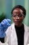 Closeup of african american microbiologist woman looking at green leaf