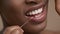 Closeup Of African American Woman Flossing Teeth Over Beige Background