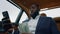 Closeup african man making video call at car. Afro man shaking money at backseat
