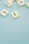 Closeup of the alphabet letters on the wooden pieces on the blue surface - space for text