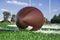 Closeup of American football on field with goal post