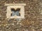 Closeup of ancient stone wall with an interesting square window