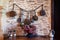 Closeup antique antique aged copper utensils, pots, pans hanging on stone brick wall at home, decoration, flowers in vase,