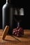 Closeup of an antique cork screw with out of focus red wine bottle, grapes and wineglass in the background