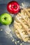 Closeup of apple pie with almonds, icing sugar and apples