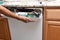 Closeup of a appliance repairman removing the control panel to a broken dishwasher