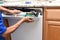 Closeup of a appliance repairman removing the control panel to a broken dishwasher