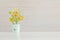 Closeup artificial orange plant with orange fruit in green pot on blurred wooden desk and wall textured background in office room