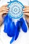 Closeup artistic woman posing holding dreamcatcher with bright blue feathers artwork