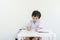 Closeup asain kid sitting to do homework after school on white wall background