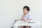 Closeup asain kid sitting to do homework after school on white wall background