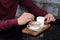 Closeup of asia hand man in the red shirt stirring the sugar in small white cup of hot coffee