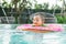 Closeup asian baby boy sit in a boat for children in the swimming pool background with smile face in happy emotion