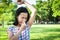 Closeup asian cute little girl feel bad foul odor situation,smelling,sniffing her wet armpit in outdoor park,beautiful child