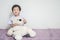 Closeup asian kid with excited face with bear doll sit on carpet with copy space